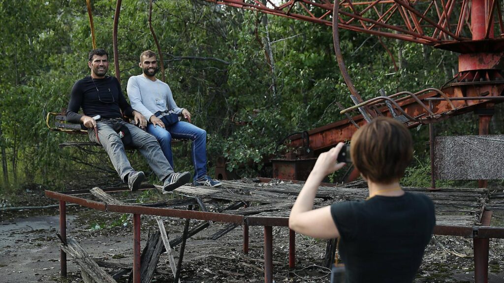 Turistes es fan fotos en una de les atraccions abandonades de la localitat fantasma de Prípiat, a pocs quilòmetres de Txernòbil. | Foto: SEAN GALLUP / GETTY.